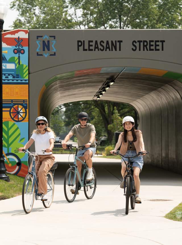 Visitors biking near the Pleasant Street tunnel mural in downtown Noblesville.