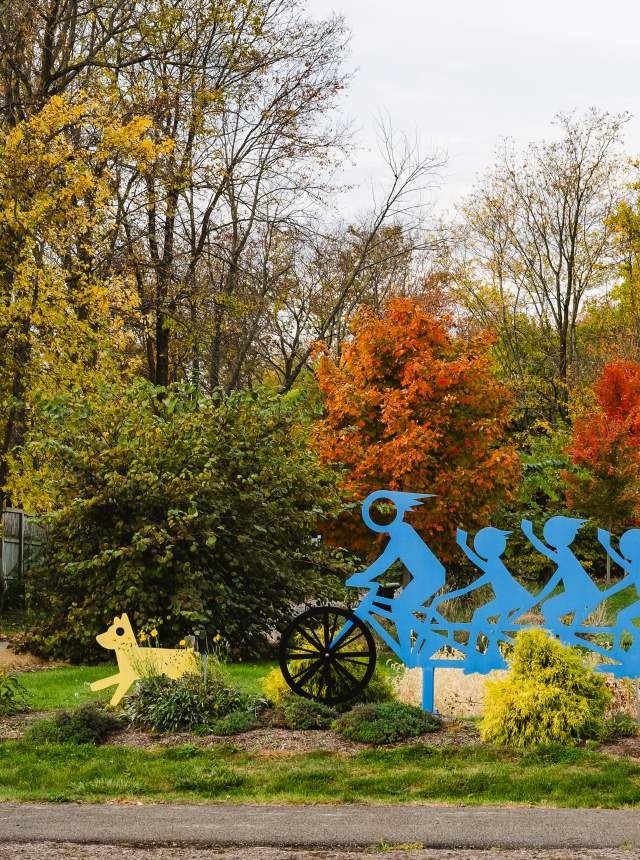 Blue sculpture depicting a family on a tandem bicycle.