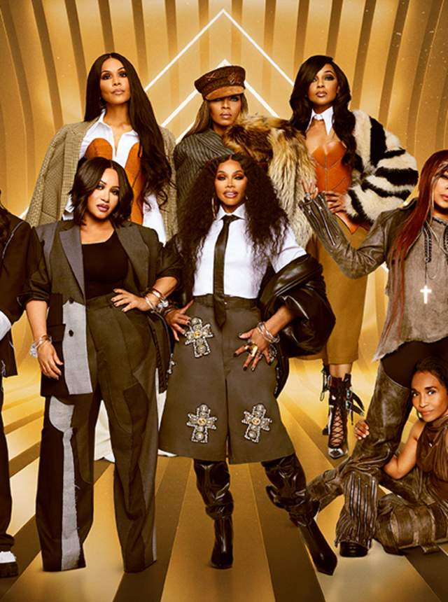 Promotional image featuring a group of nine performers posed together against a glowing gold geometric backdrop, wearing coordinated fashion-forward outfits in neutral tones and standing in dynamic, layered poses.