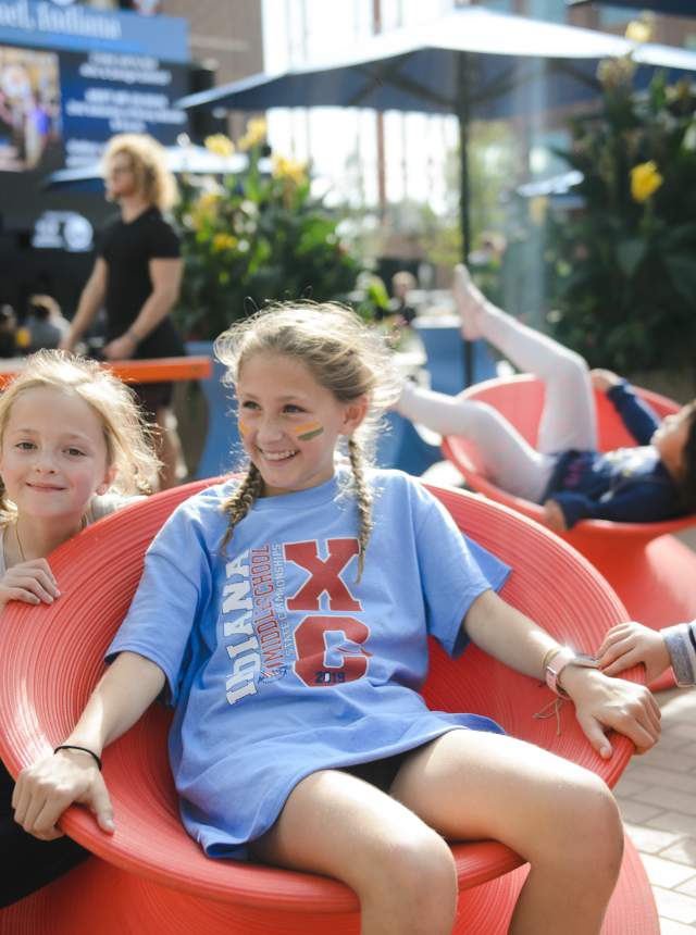 Two girls relaxing in red chairs at Midtown Plaza, along the Monon Trail. Photo by: Amanda Reynolds