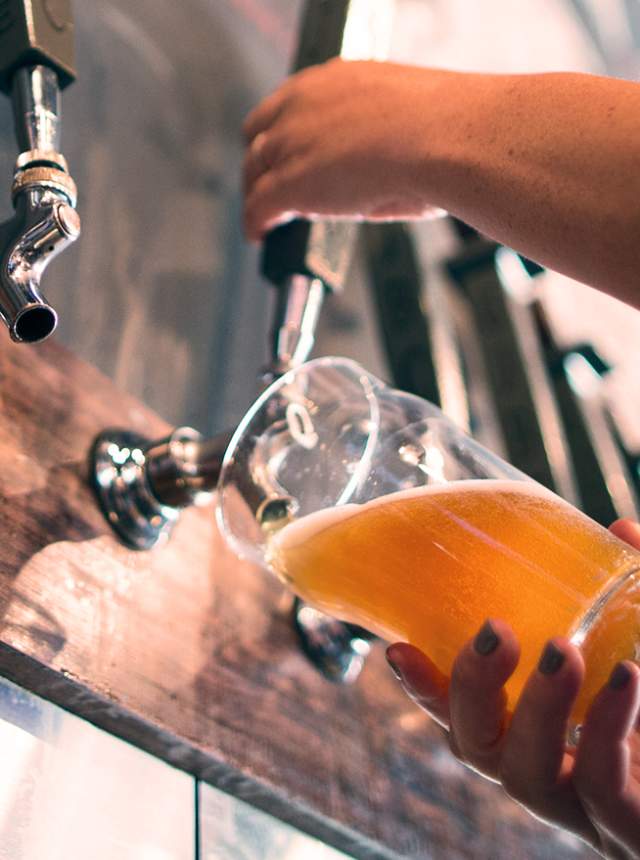 Hand pouring beer from tap