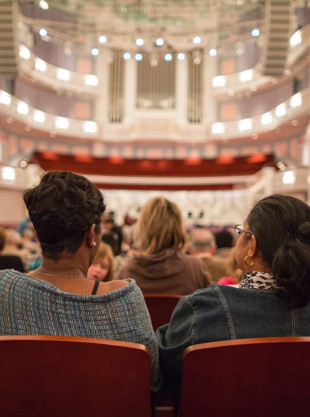 Row of people sitting in spacious Palladium Theater ready for performance to begin