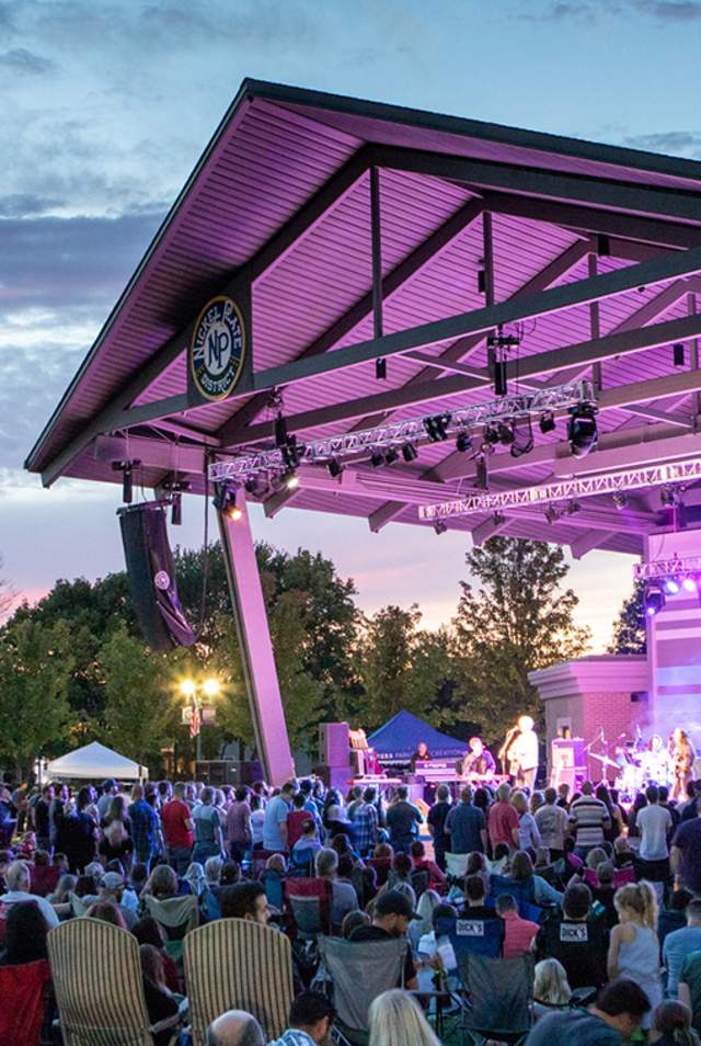 A crowd enjoys a concert at the Nickel Plate District Amphitheater in Fishers, IN at sunset