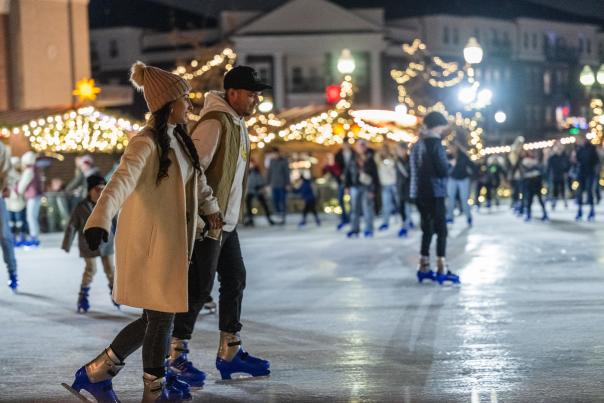 Visitors skating on the Ice at Carter Green at the Carmel Christkindlmarkt German market at night.