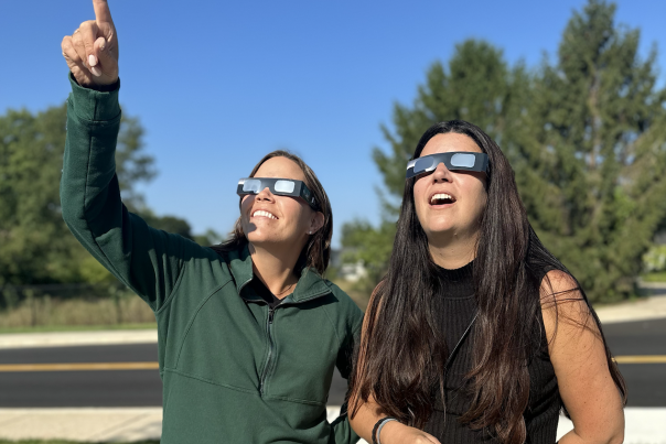 Image showing two people outdoors pointing toward the sky during the eclipse.