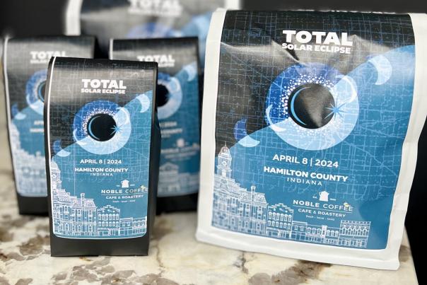 Eclipse Noble Coffee display featuring blue branded coffee bags arranged on a shelf.