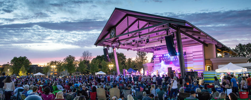 A crowd enjoys a concert at the Nickel Plate District Amphitheater in Fishers, IN at sunset