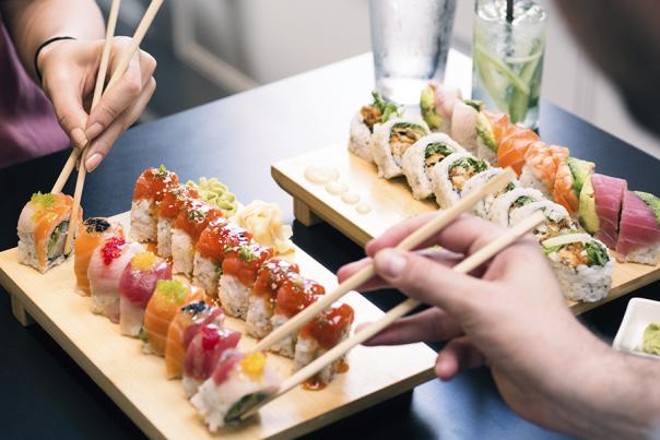 Two bamboo dishes with colorful sushi rolls