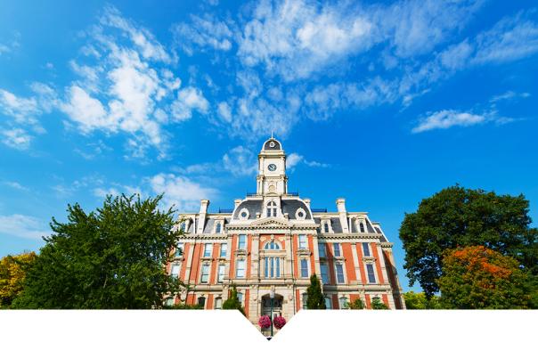 A historic courthouse building with a clock tower under a blue sky.