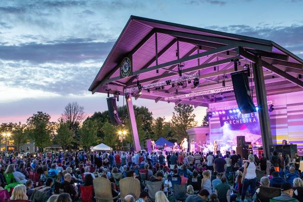 A crowd enjoys a concert at the Nickel Plate District Amphitheater in Fishers, IN at sunset