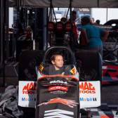 A child sits inside a dragster at U.S. Nationals