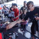 A fan shakes hands with a driver during an autograph session at U.S. Nationals
