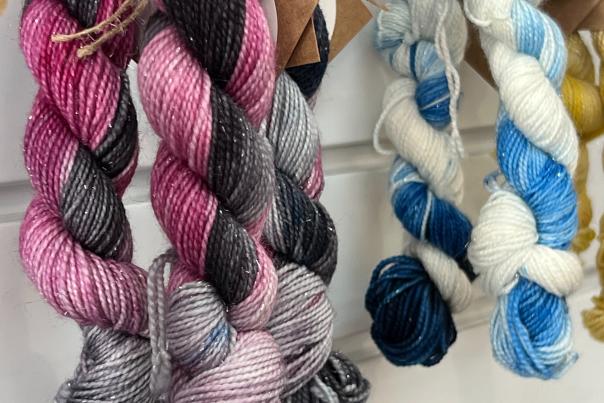 Pink, black, blue and white dyed yarn available for purchase.