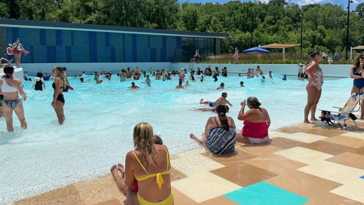 Families enjoying a zero-entry wave pool at Murphy Aquatic Park in Avon, on a sunny summer afternoon.