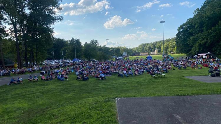 Residents in lawn chairs and blankets fill the greenspace at Ellis Park, ready to listen to live music.