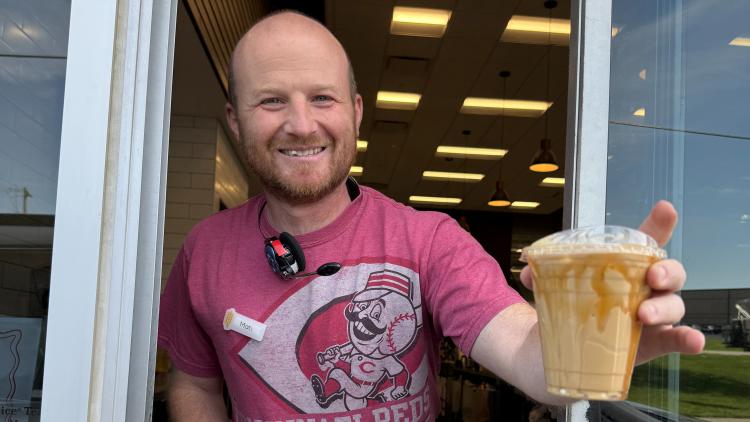 Service with a Smile. Fields coffee employee hands out coffee and service with a smile through the drive-thru.