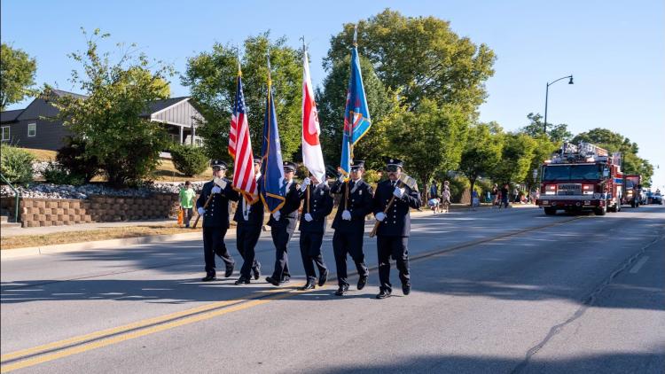Six men present the colors ahead of the Quaker Day Parade.