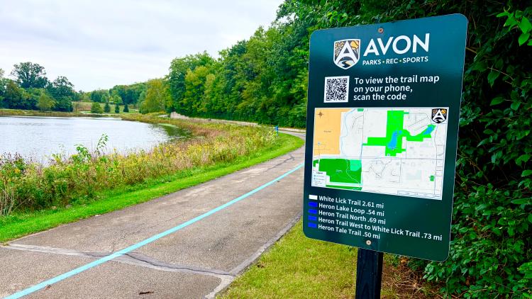 A trail sign and a walking trail at Blue Heron Park