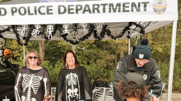 Staff from the Plainfield Police Department dressed in skeleton costumes and handing out candy.