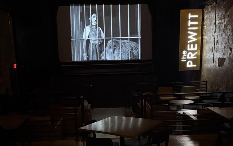 An old black and white movie is shown inside an empty dining area at the Prewitt Restaurant + Lounge in Plainfield, Indiana