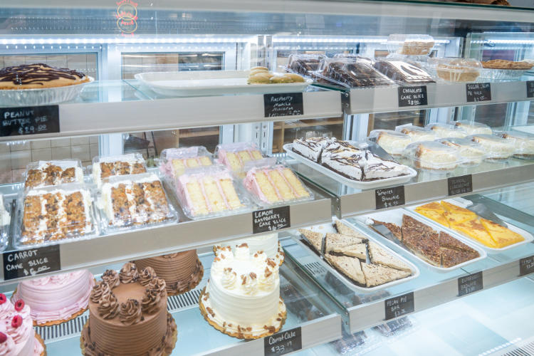 Cakes and other baked items inside the desserts case at Roots Market + Eatery in Plainfield