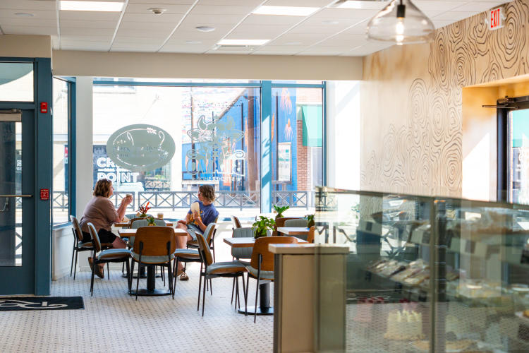 Two women enjoy a meal in the dining area of Roots Market + Eatery in Plainfield, Indiana