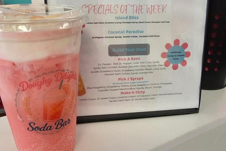 A Doughy Delights dirty soda next to a drink menu