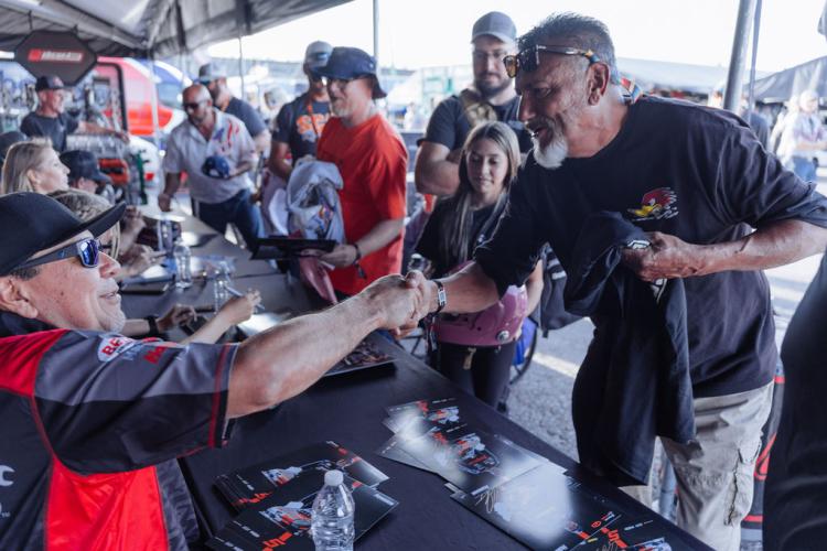 A fan shakes hands with a driver during an autograph session at U.S. Nationals