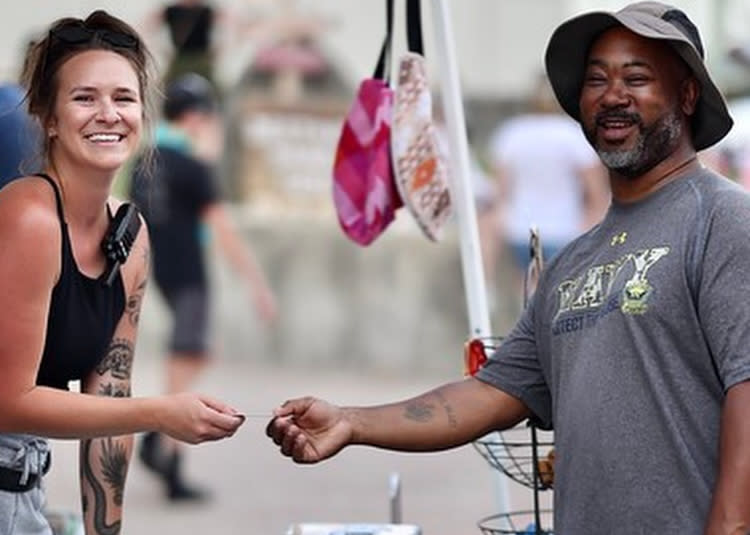Woman and man exchanging money at a booth at the Destination Danville Festival