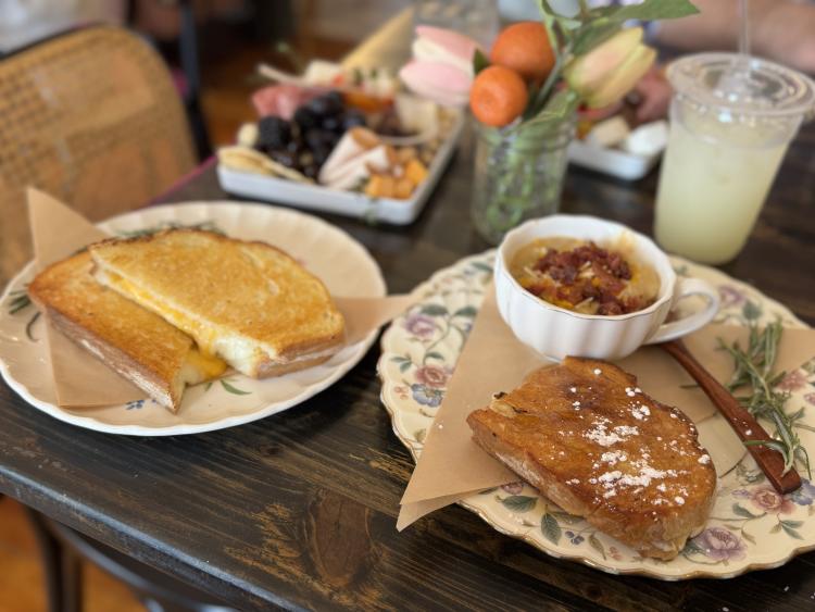 Two versions of the famous toasties at Brie & Bartlett. On the left, 'The Danny', your classic grilled cheese. On the right, the 'Bartlett Brunch Toastie', with powdered sugar and honey on the top, served with a side of loaded potato soup.