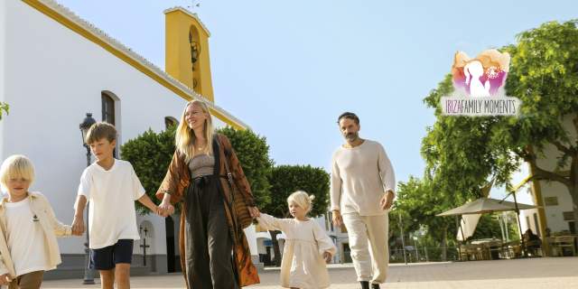 Una familia con tres hijos pasea frente a una de las iglesias de Ibiza.
