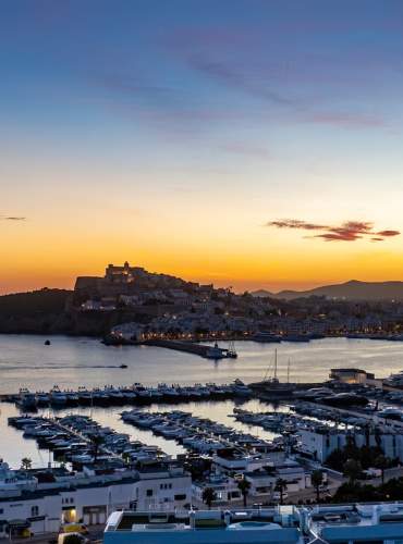 Um casal tira uma selfie junto à placa de Ibiza-Eivissa, com Dalt Vila ao fundo.
