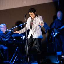 A man dressed like Elvis performs on stage