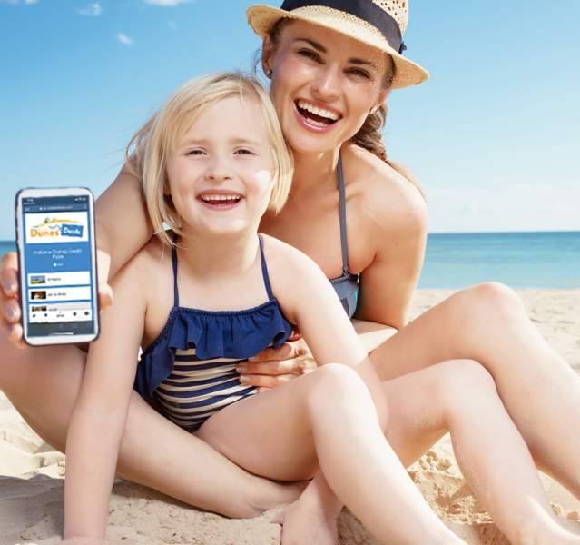 Happy woman and child sitting on the beach