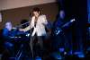 A man dressed like Elvis performs on stage