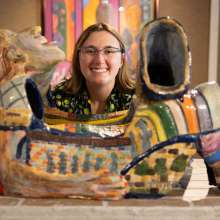 An artist's head lies above a sculpture of a reclining person in the Chesterton Art Center.