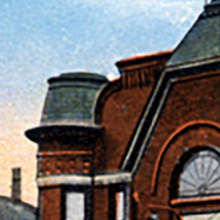Historic architectural detail featuring a brick building and distinctive rooftop tower.