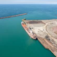 An aerial view of a port on Lake Michigan. A large ship is docked.
