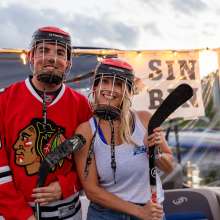 A man and woman are dressed in hockey gear for the picture.