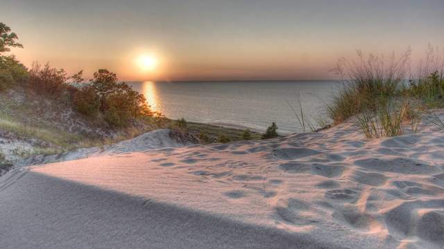 A sunset over the water, as viewed form the dunes
