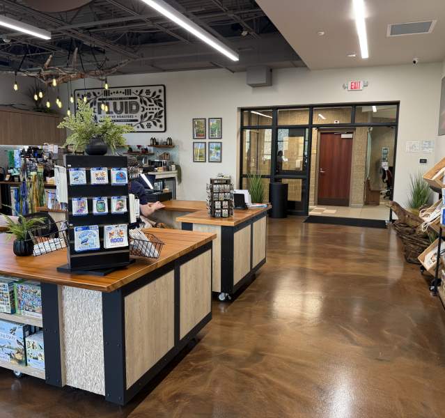 Interior view of Beaches & Beyond Gift Shop at the Indiana Dunes Visitor Center featuring gift displays, games, souvenirs, and the FLUID Coffeebar.
