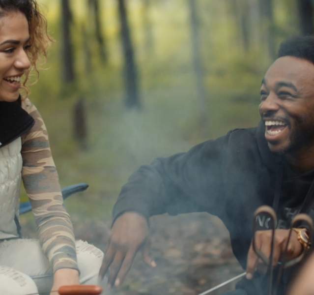 People sitting around campfire, laughing