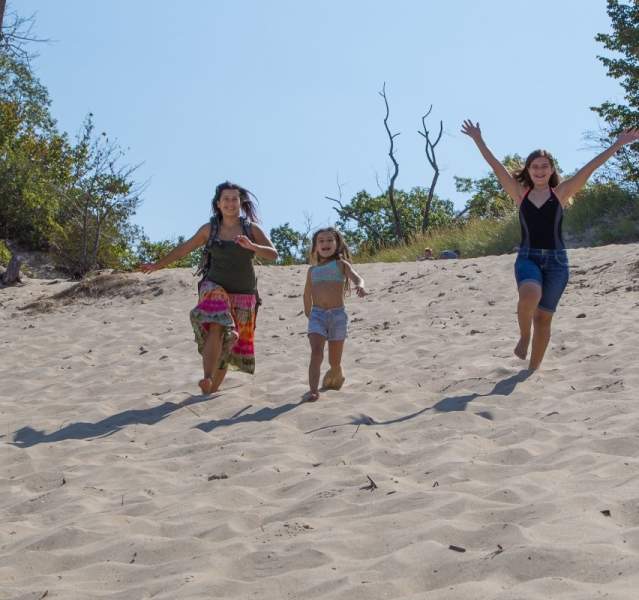 Family running down a beach dune