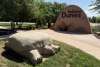 A large stone turtle sculpture at the Indiana Dunes Visitor Center, part of the Indigenous Cultural Trail, with a rock engraved with the Indiana Dunes logo in the background.