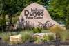 A dune-shaped sign says "Indiana Dunes Visitor Center" and has imagery of a sandhill crane and marram grass.