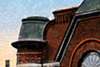 Historic architectural detail featuring a brick building and distinctive rooftop tower.