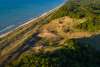 Aerial view of green vegetation on dunes near the blue water