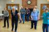 A group of seniors is doing a line dance