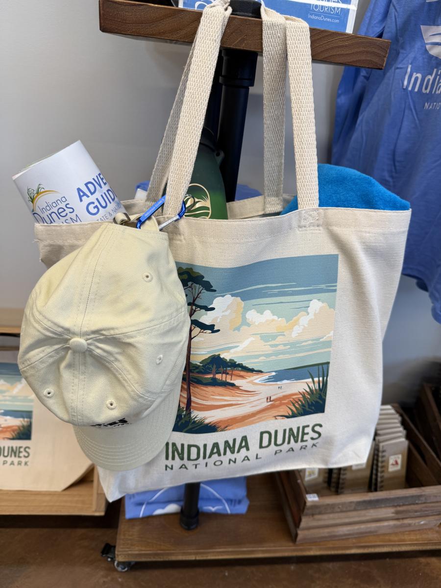 An Indiana Dunes beach bag filled with beach souvenirs hangs in a gift shop.