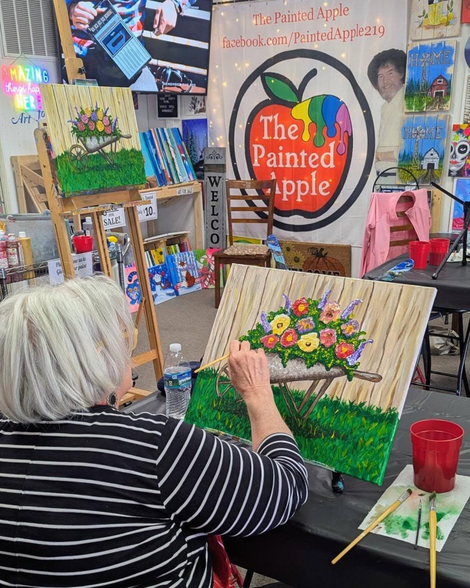 Visitor painting on a canvas during an art class at The Painted Apple Creative Studio in Portage, Indiana.